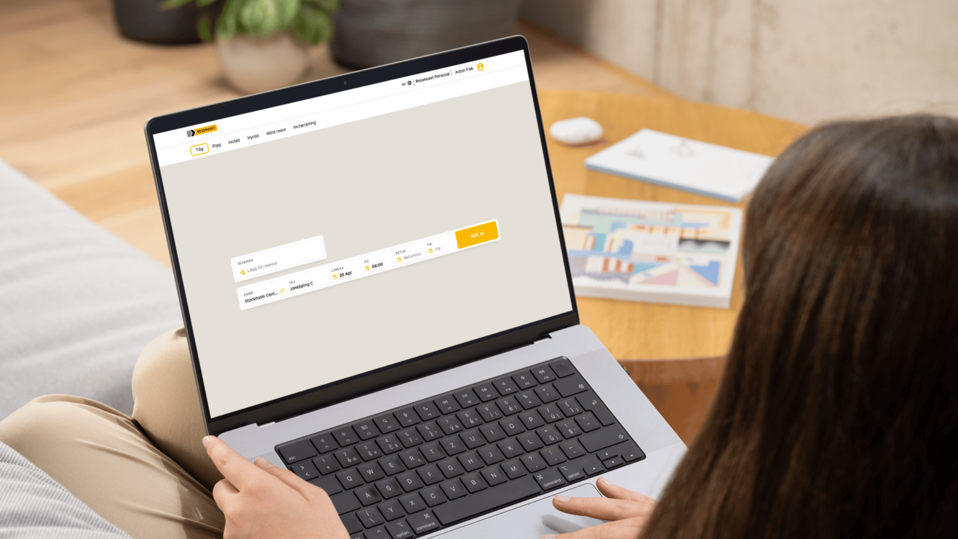 Person som bokar tågresa i Resehusets självbokningssystem på laptop